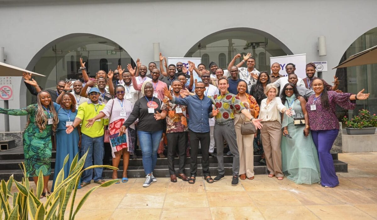 Smepaks-team-building-event-in-africa-overview, diverse group of professionals celebrating success at SMEPEAKS business conference, fostering networking and collaboration, outdoor setting with modern architecture, vibrant and enthusiastic atmosphere, innovative SME support.