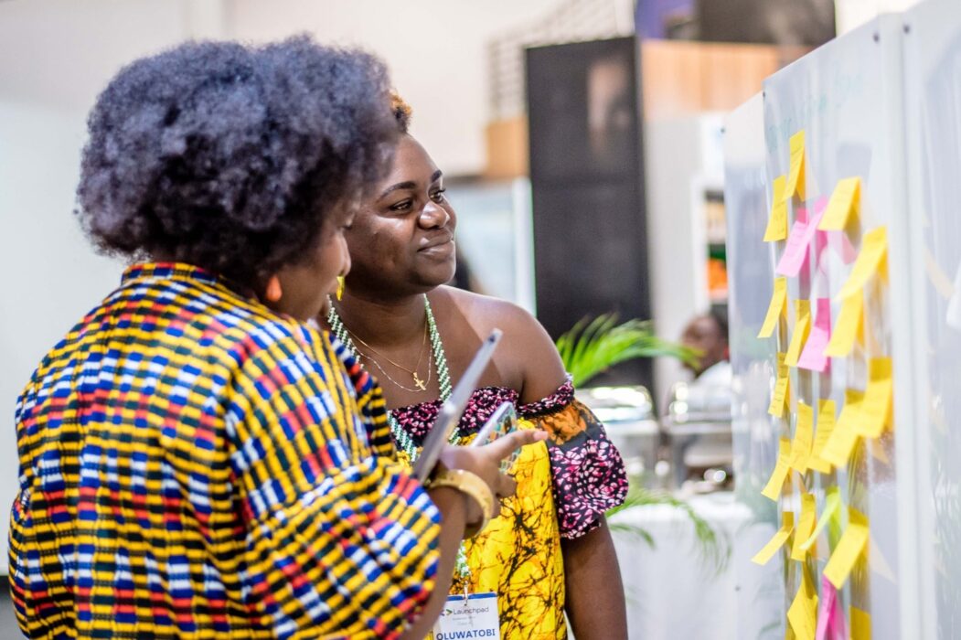 Two female Africans looking at a banner : Google for Startups Accelerator Africa 2025