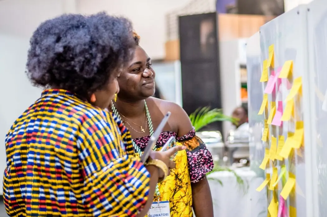 Two female Africans looking at a banner : Google for Startups Accelerator Africa 2025