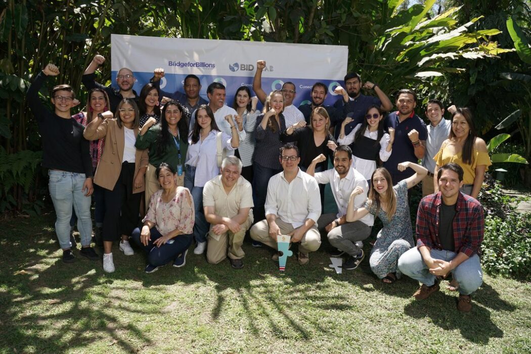 Diverse group of professionals celebrating success at SMEPEAKS event in lush outdoor setting, demonstrating teamwork, motivation, and community engagement in small and medium enterprise development.