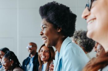 Diverse group of smiling business professionals attending a corporate training session or seminar, showcasing inclusivity, engagement, and professional development.
